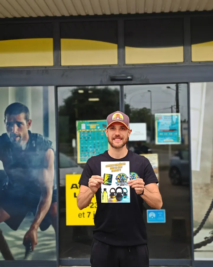 Emmanuel, le gérant, présente son livre « Comment bien débuter dans sa salle de sport » devant la salle