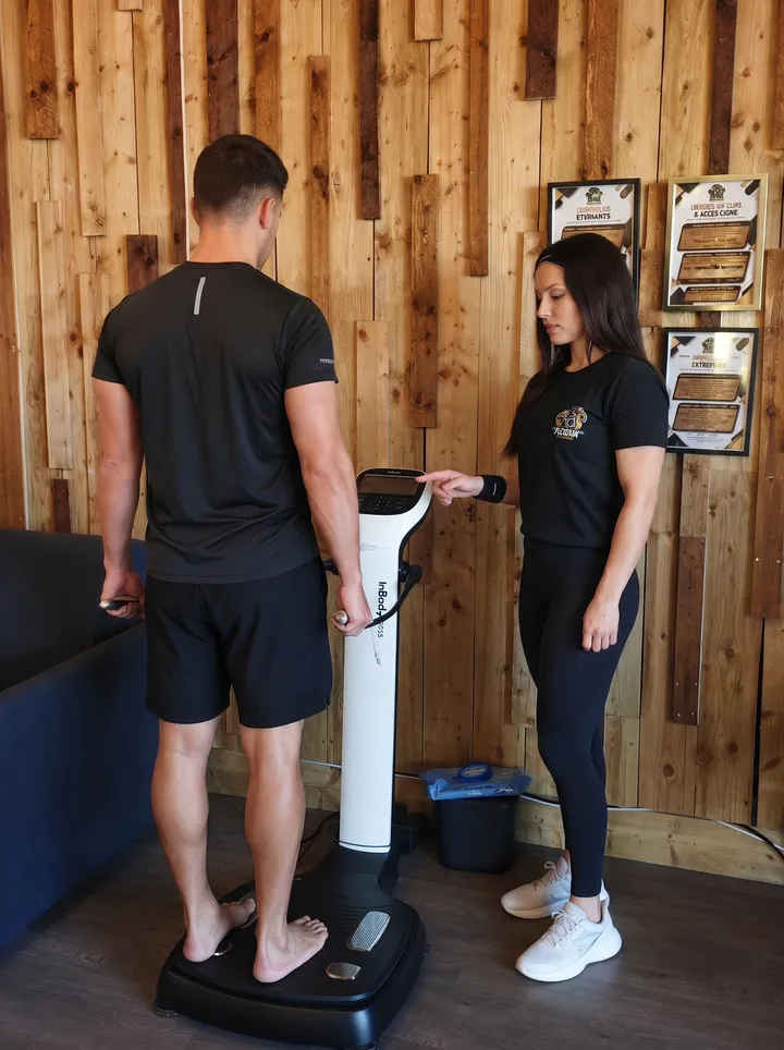 Un coach réalise un bilan InBody avec un adhérent sur la machine de composition corporelle